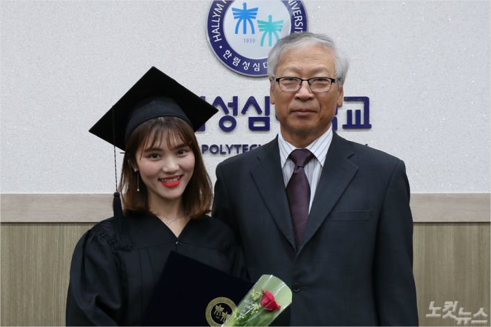 22일 한림성심대 하계졸업식에서 전문학사 학위를 받은 베트남 유학생 호앙 넙하 씨가 우형식 총장과 졸업 기념사진을 촬영하고 있다.(사진=한림성심대 제공)