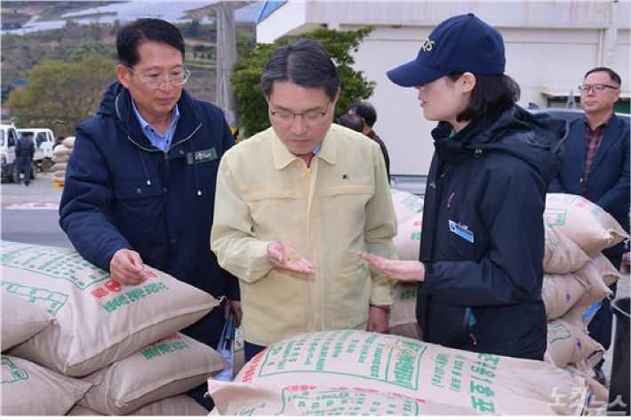권오봉 여수시장(가운데)이 7일 돌산 도실마을 공공비축미곡 매입현장에서 쌀을 살펴보고 있다(사진=여수시)