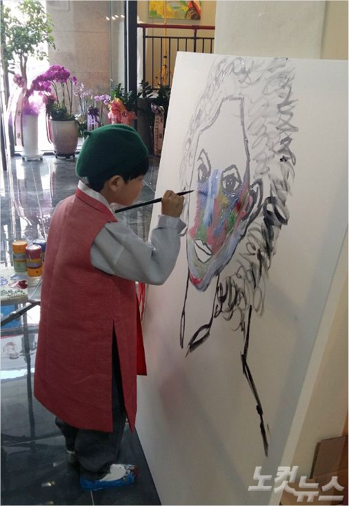 관중 앞에서 그림 작업을 하고 있는 화가 김하민(8)군.<사진=성원아트홀 제공>