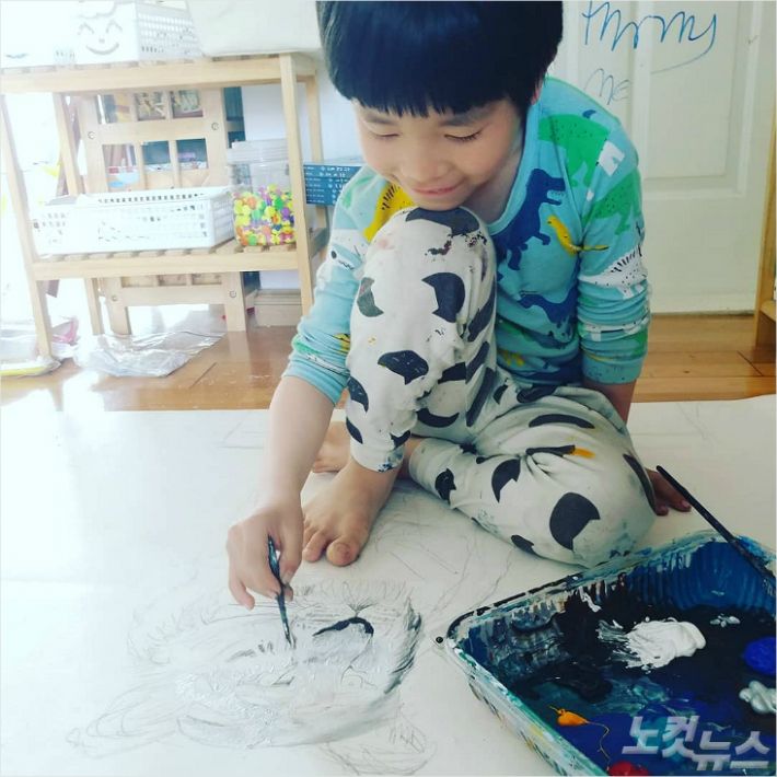 집에서 그림그리기 작업을 하고 있는 화가 김하민(8)군.<사진=성원아트홀 제공>