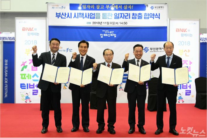 BNK금융그룹이 8일 개최한 '2018 부산 잡(Job) 페스티벌’에서 부산시 산·학·관·기업·단체가 ‘일자리창출 업무협약’을 체결하고 있다. 사진 왼쪽부터 김영도 동의과학대학교 총장, 김지완 BNK금융그룹 회장, 오거돈 부산시장, 최금식 선보공업 회장, 이상우 부산시 맞춤훈련협의회 회장(사진 = BNK금융그룹 제공)