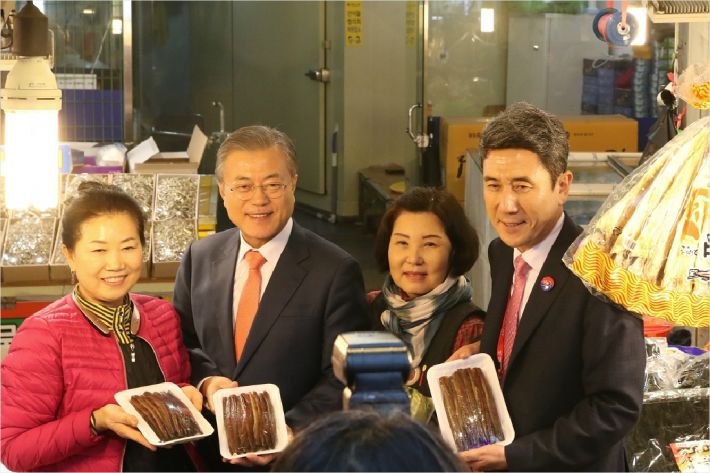 문재인 대통령이 이강덕 포항시장과 함께 포항 죽도시장을 찾아 과메기를 산 뒤 상인들과 기념사진을 촬영하고 있다(사진=포항시 제공)