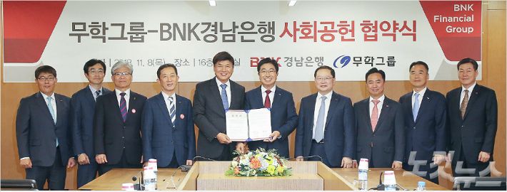 무학은 8일 경남은행과 사회공헌 상호협력 업무협약을 체결했다. 사진 중앙 왼쪽부터 최재호 무학 회장, 황윤철 BNK경남은행장 (사진 = 무학 제공)