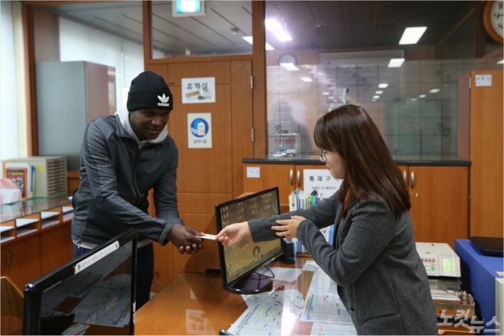 케냐 출신 마라토너 윌슨 로야나에 에루페가 청양군 정산면사무소에서 주민등록증을 받고 있다. (사진=청양군 제공)