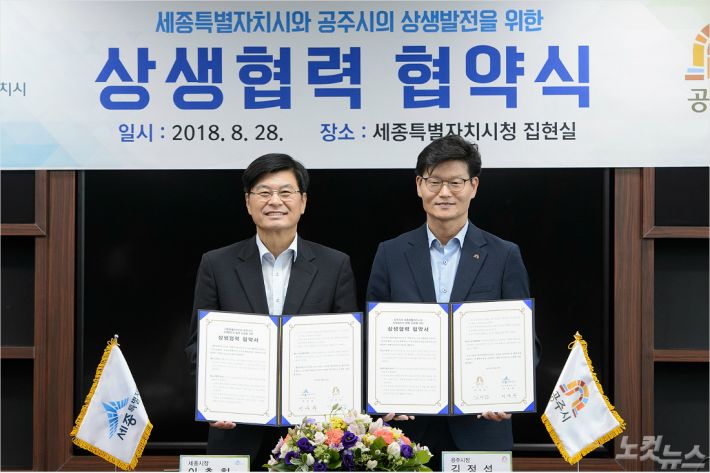 지난 8월, 세종시와 공주시 간 상생협력 협약식에서 이춘희 세종시장(왼쪽)과 김정섭 충남 공주시장이 협약서를 들어보이고 있다. (사진=세종시 제공)