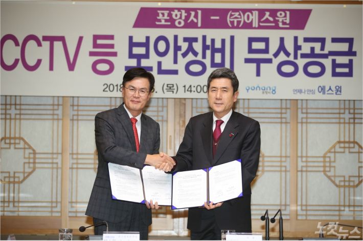 (주)에스원과 포항시가 지진피해 주택건설 보안장비 무상지원 협약을 체결하고 있다(사진=포항시 제공)