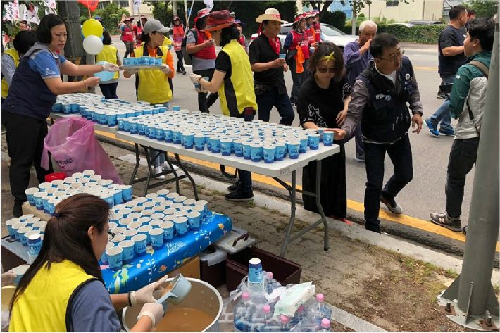 거리행진을 하는 조합원들에게 음료를 나눠주는 모습.(사진 = 민주노총 울산본부 제공)