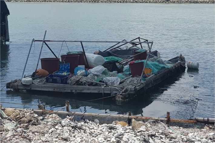 부산 강서구 한 섬 입구에 각종 어업용 도구가 어지럽게 올려진 채 방치된 작업용 바지. (사진=부산CBS 박진홍 기자)