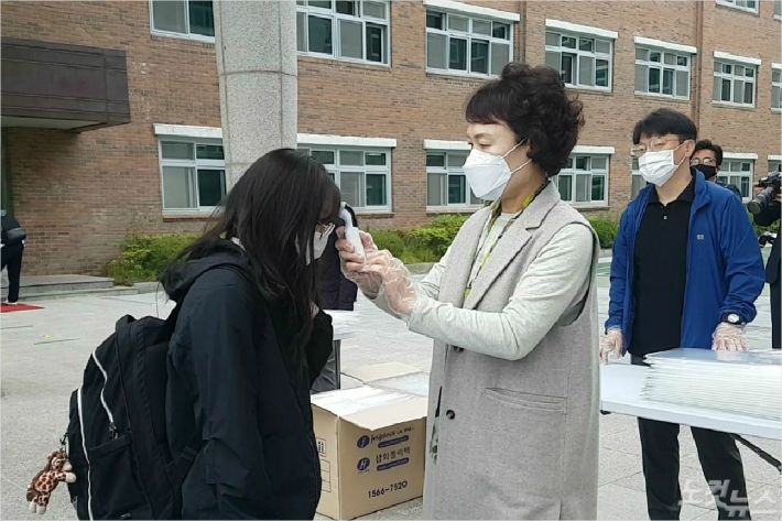 20일 오전 대전 전민고등학교에서 한 교사가 등교하는 학생의 발열을 체크하고 있다. (사진=김정남 기자)