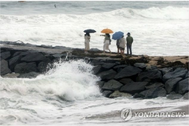 동해안에 높은 파도가 일고 있는 가운데 해안가를 거닐고 있는 관광객들. (사진=연합뉴스)