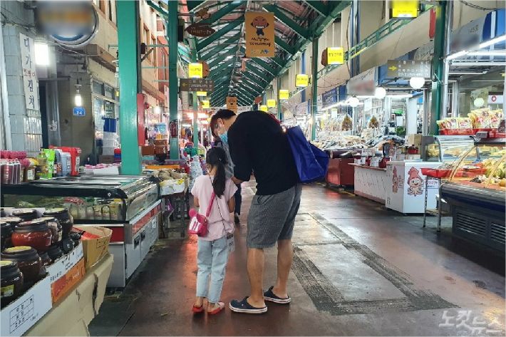 10일 강릉시 흥정학교에 참여한 한 학부모와 딸 아이가 구매 목록을 살펴보고 있다. (사진=유선희 기자)
