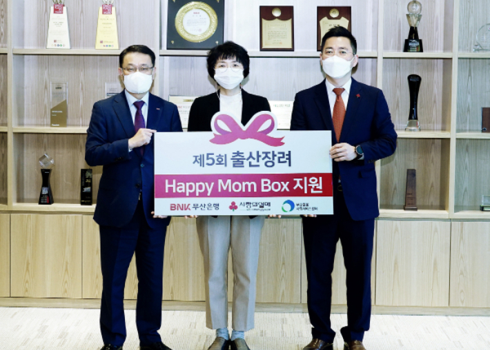 BNK부산은행은 21일 본점에서 저소득 출산가정 지원을 위한 육아용품 꾸러미 '해피맘박스'를 부산사회복지공동모금회에 전달했다. 사진 왼쪽부터 부산은행 손강 경영전략그룹장, 부산돌봄사회서비스센터 안혜경 센터장, 부산사회복지공동모금회 박은덕 사무처장. 부산은행 제공