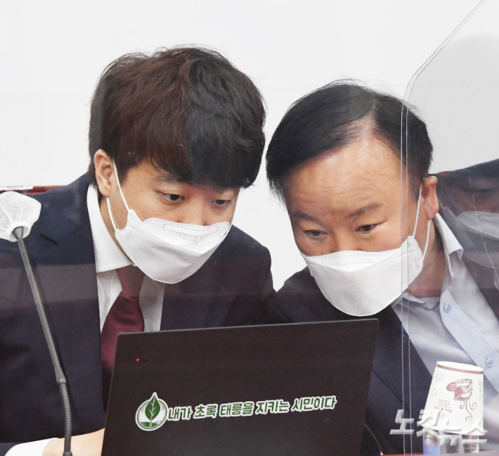국민의힘 이준석 대표가 28일 국회에서 열린 최고위원회의에서 김재원 최고위원과 대화를 하고 있다. 윤창원 기자