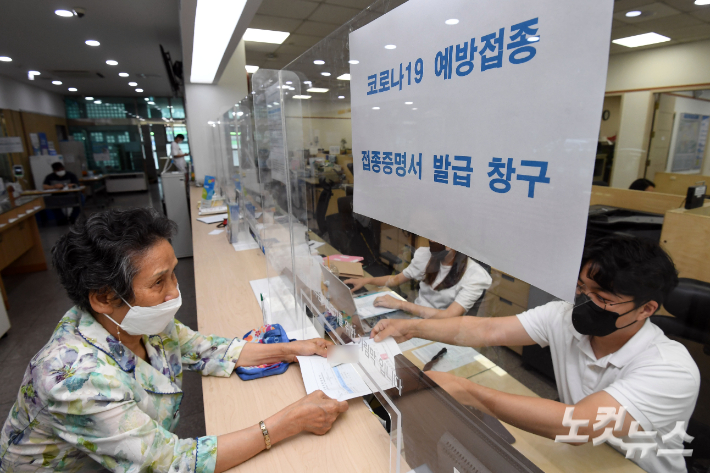 서울 양천구 신정1동 주민센터에서 어르신들이 백신접종 증명서와 스티커를 받고 있다. 황진환 기자