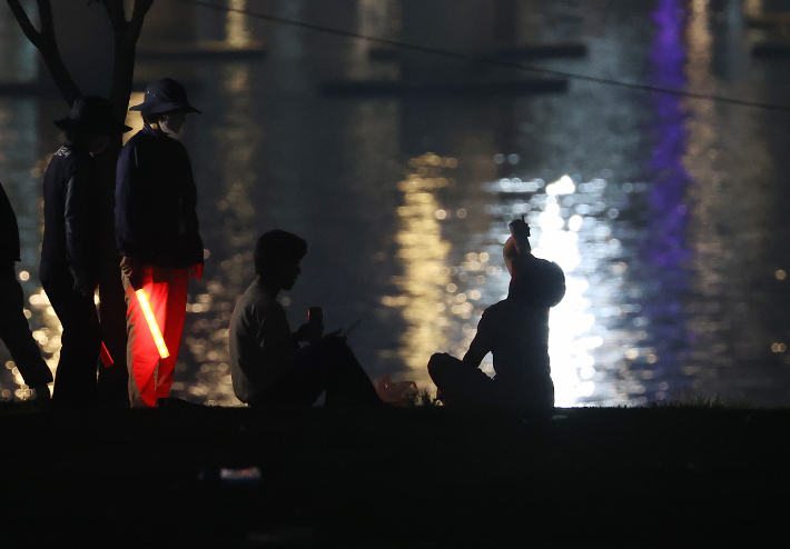 서울 여의도 한강공원에서 서울시 관계자들이 야간 야외 음주 금지 계도활동을 벌이는 모습. 연합뉴스