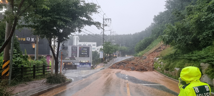 7일 부산지역에 내린 폭우로 곳곳에서 피해가 이어졌다. 이날 오후에는 부산 남구 용호동 야산에서 토사가 쏟아져 도로를 덮쳤다. 부산소방재난본부 제공