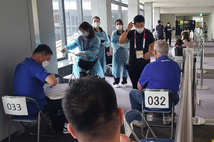 도쿄 올림픽을 위해 일본에 도착한 해외 입국자들이 지난 11일 일본 나리타 공항에서 검역 절차를 통과하기 위해 줄지어 대기하고 있다. 연합뉴스