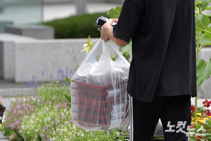 수도권 사회적 거리두기 4단계 격상 둘째날인 12일 서울 종로구의 한 거리에서 포장된 도시락을 든 직장인이 발걸음을 옮기고 있다. 박종민 기자