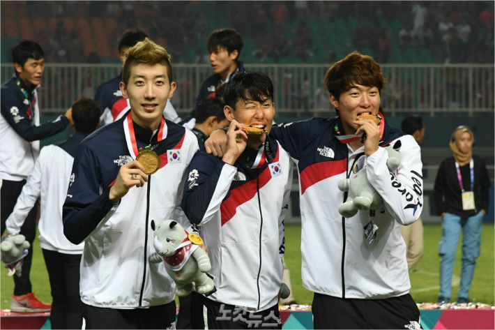 손흥민 선수(가운데)가 금메달을 깨무는 세레머니를 하는 모습. 이한형 기자