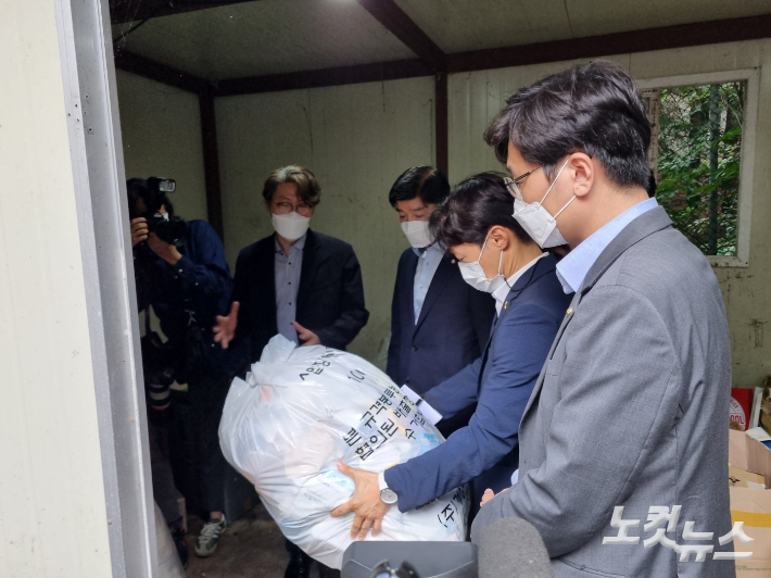 숨진 서울대 청소노동자가 일했던 쓰레기장에서 100ℓ짜리 쓰레기봉투를 들어보는 더불어민주당 산재 TF 이탄희 의원. 임민정 기자