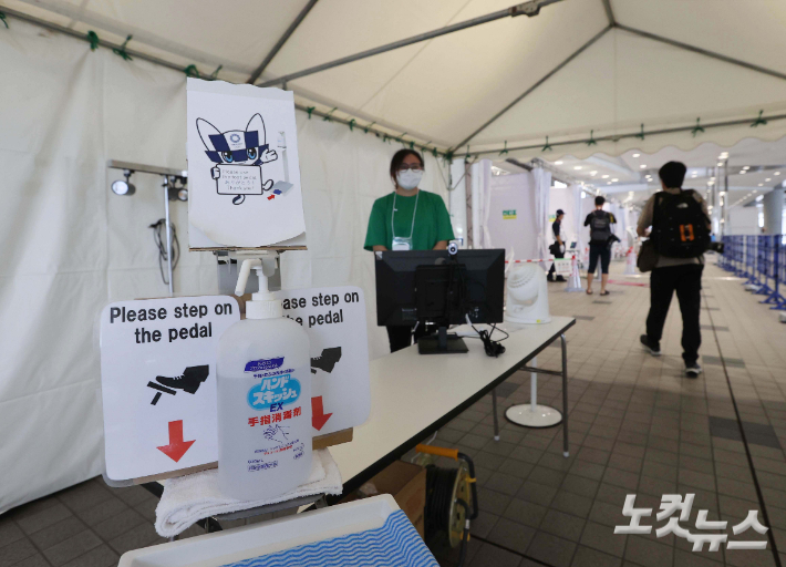 지난 15일 도쿄 오다이바 국제전시장 '도쿄 빅 사이트' 내 마련된 메인 프레스센터(MPC)에서 취재진이 손 소독을 하고 입장하고 있다. 올림픽사진공동취재단