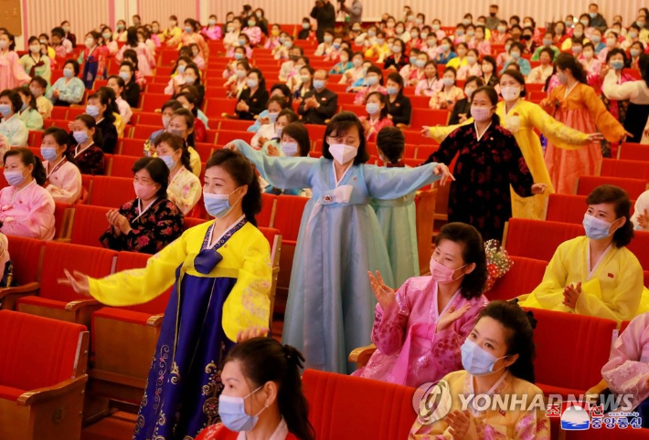 한복을 입고 마스크를 쓴 북한 여성 관객들이 공연을 관람하며 춤을 추고 있다. 연합뉴스