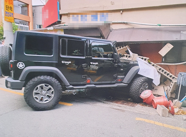 부산 한 주차장에서 주차 관리 요원이 몰던 차량이 구급차 등 2대를 들이받은 뒤 인근 식당으로 돌진했다. 부산경찰청 제공