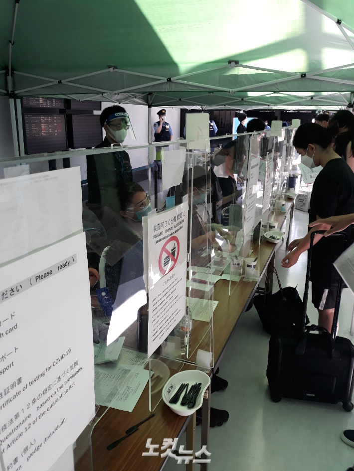 나리타 공항에 입국한 대회 관계자들이 코로나19 타액 검사를 받기 위해 키트를 제공받는 모습. 도쿄=노컷뉴스