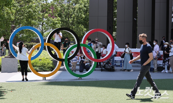 22일 시민들이 개막식이 열릴 도쿄 올림픽스타디움 앞 오륜기 조형물에서 기념촬영을 하고 있다. 도쿄=올림픽사진공동취재단