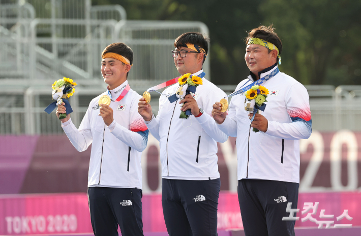 김제덕,김우진, 오세혁(왼쪽부터) 선수가 26일 도쿄 유메노시마 양궁장에서 열린 도쿄올림픽 남자 양궁단체 메달 수여식에서  금메달을 들어 보이며 기뻐하고 있다. 올림픽사진공동취재단