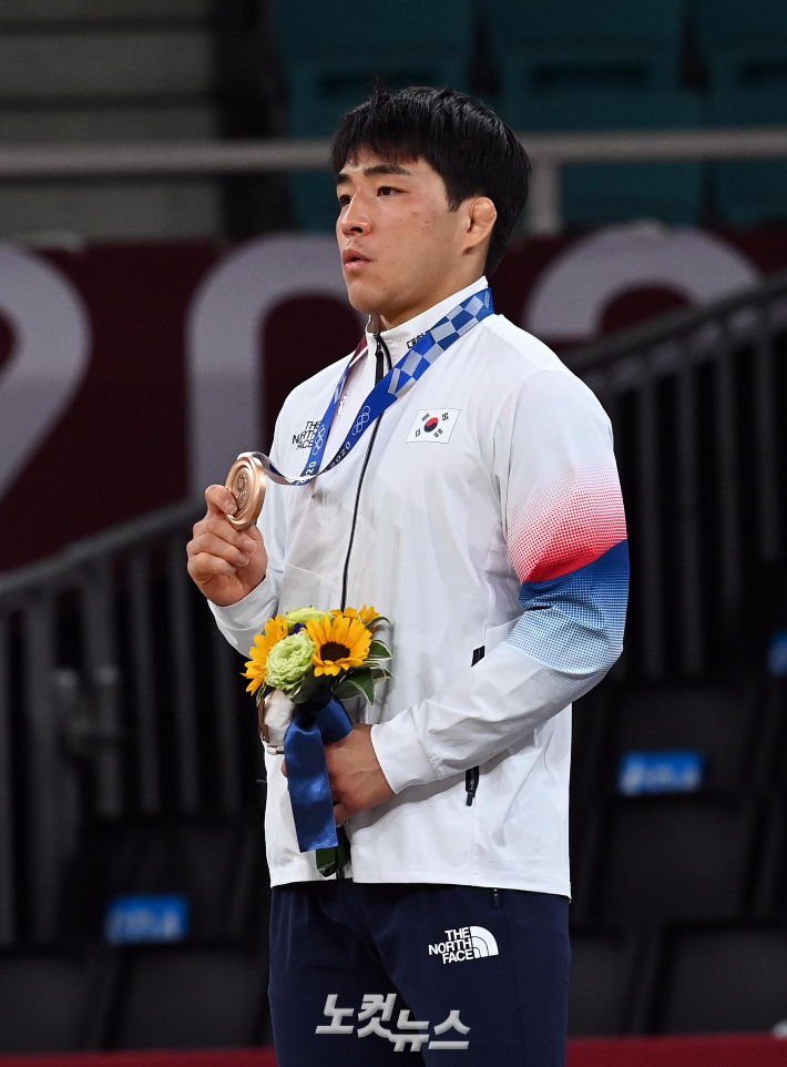 26일 일본 도쿄 지요다구 무도관에서 열린 도쿄올림픽 유도 남자 73kg급 시상식에서  재일동포 3세 안창림이 태극 마크를 가슴에 단 채 동메달을 받고 있다. 도쿄=올림픽사진공동취재단