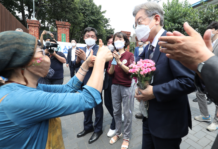 이재명 경기지사가 대구 중구 남산동 전태일 열사 옛집을 찾아가던 길에 시민으로부터 꽃다발을 받고 있다. 연합뉴스