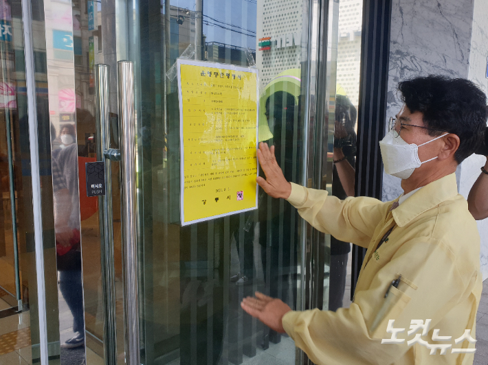 김한근 시장이 1일 방역수칙을 위반한 강릉시 주문진의 한 대형호텔에  긴급 행정명령(영업정지) 안내문을 부착하고 있다. 전영래 기자