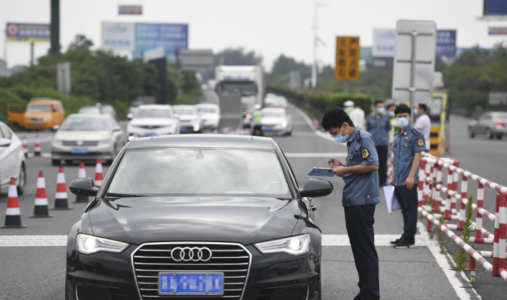 지난달 25일 중국 난징시 공무원이 난징 근처의 고속도로 톨게이트에서 승용차 운전자의 코로나 PCR검사 확인서를 확인하고 있다. 연합뉴스