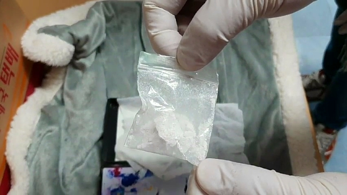 경찰이 A씨 일당이 택배 상자에 담아 배송한 헤로인 샘플을 꺼내고 있다. 부산경찰청 제공