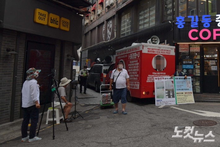 지난 29일 '쥴리의 남자들' 벽화 앞에서 보수성향 유튜버들이 차량으로 벽화를 가리고 있다. 박종민 기자
