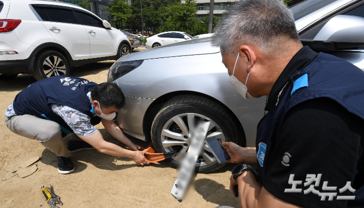 서울 강남구 일대에서 38세금징수과 단속반원들이 체납차량에 대해 차량용 족쇄를 채우고 있다. 이한영 기자