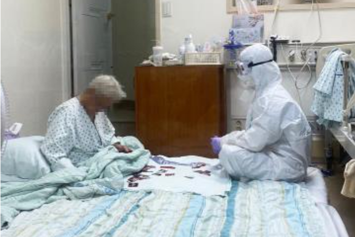 방호복을 입은 채 할머니와 화투 놀이를 한 간호사의 모습에 온라인에서 화제가 됐다. 연합뉴스
