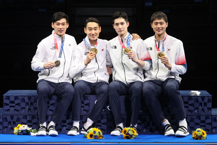 구본길(왼쪽부터), 김정환, 김준호, 오상욱이 지난달 28일 일본 지바의 마쿠하리 메세에서 열린 2020 도쿄올림픽 펜싱 남자 사브르 단체전 시상식에서 금메달을 들어보이고 있다. 올림픽사진공동취재단