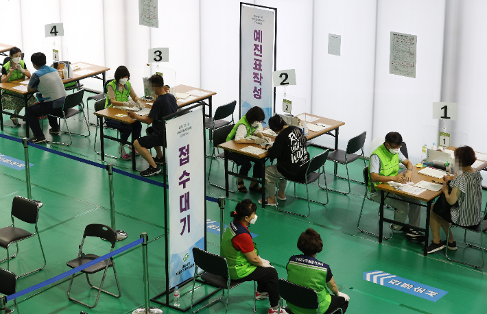 서울 서대문구 북아현문화체육센터에 마련된 예방접종센터에서 시민들이 예진표를 작성하는 모습. 연합뉴스