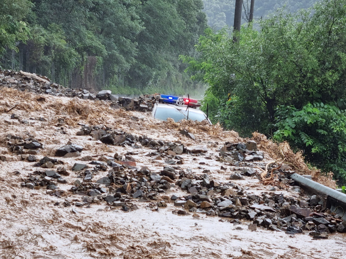 절개지에서 흘러내린 토사에 잠긴 순찰차량. 독자 제공