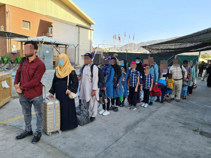 아프간에서 한국 정부를 도운 아프간 현지인들이 지난 25일 카불 공항에 도착한 한국 공군 수송기에 탑승하기 위해 줄을 서서 기다리고 있다. 외교부 제공