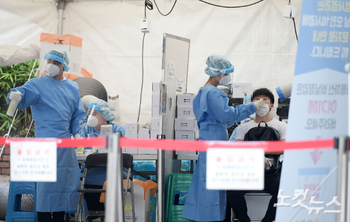 지난 23일 서울 양천구 선별진료소에서 시민들이 검사를 받기 위해 줄 서고 있다. 이한형 기자