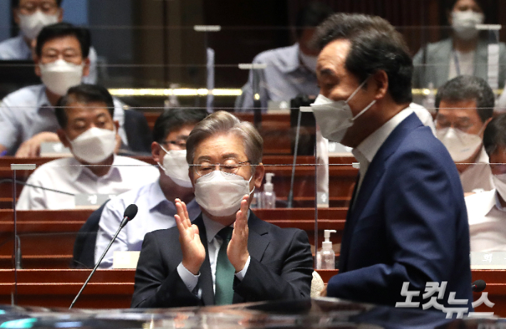 더불어민주당 대선 경선 후보인 이재명 경기도지사가 26일 국회에서 열린 2021년 정기국회대비 국회의원 워크숍에서 단상으로 향하는 이낙연 대선 경선 후보를 향해 박수를 치고 있다. 윤창원 기자