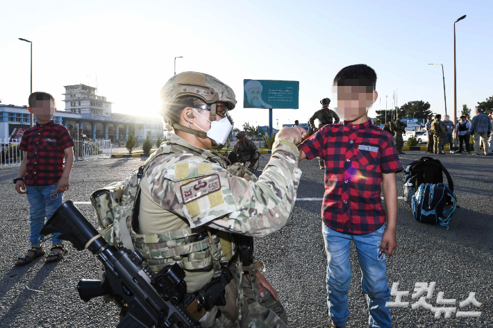 공군 최정예 특수부대 요원인 공정통제사가 25일 아프가니스탄 카불공항에서 한국으로 이송될 아프간 현지 조력자의 자녀들에게 간식을 제공하고 있다. 공군제공