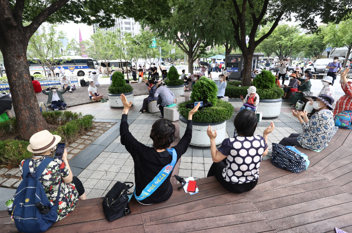 시설 폐쇄 결정을 받은 서울 성북구 사랑제일교회 신자들이 지난 22일 서울 광화문 동화면세점 앞에서 현장 예배를 하고 있는 모습. 연합뉴스