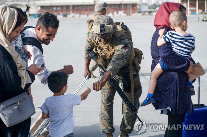 아프간 난민 아이와 주먹 인사하는 미군. 사진은 기사와 관련 없음. 연합뉴스