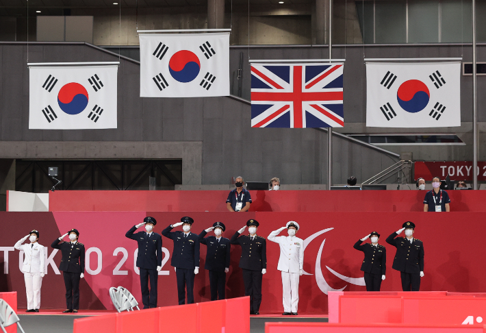 30일 오전 일본 도쿄 메트로폴리탄체육관에서 열린 2020 도쿄 패럴림픽 남자 탁구 개인전 시상식에서 태극기 3개가 게양되고 있다. 연합뉴스