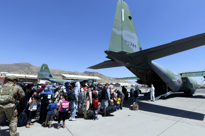 한국으로 이송될 아프간인 현지 조력자와 가족들이 지난 25일(현지시간) 아프가니스탄 카불공항에서 공군 C-130J 수퍼허큘리스 수송기에 탑승하기 위해 대기하고 있다. 공군 제공
