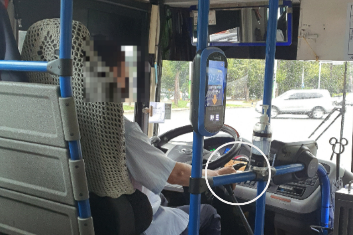 버스 기사가 계기판 위에 핸드폰을 올려 영상을 재생한 모습. 창원시청 대중교통 민원신고 게시판 캡처
